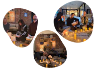 a group of people sitting around a table with candles